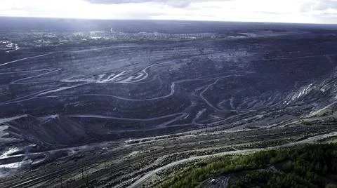 Coal mining at an open pit. Top view of the quarry. Dozers and trucks at Stock Photos
