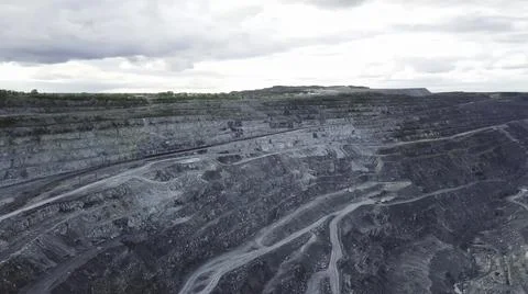Coal mining at an open pit. Top view of the quarry. Dozers and trucks at Stock Photos