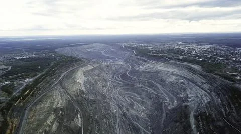 Coal mining at an open pit. Top view of the quarry. Dozers and trucks at Stock Photos