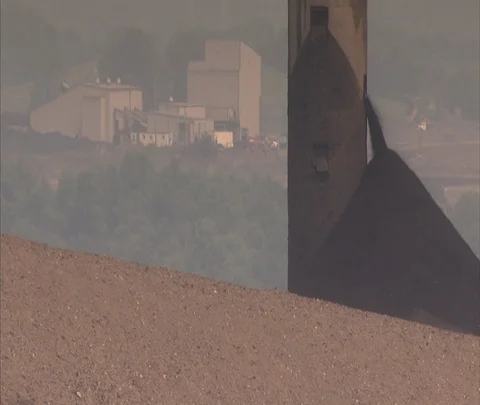 Coal spilling out of silo onto pile, Century Mine buildings in background Stock Footage 86696080