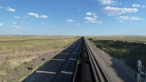 Coal train transporting coal through an empty rural landscape Stock Photos