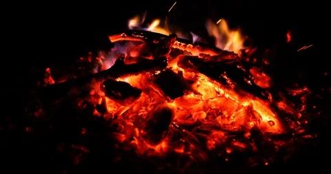 Coals with a slight burning flame that burn again in a slow slow motion capture Stock Footage