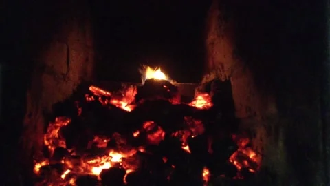 Coals Smolder with a Flame of fire in The Dark of Stove Close Up Stock Footage 167970954