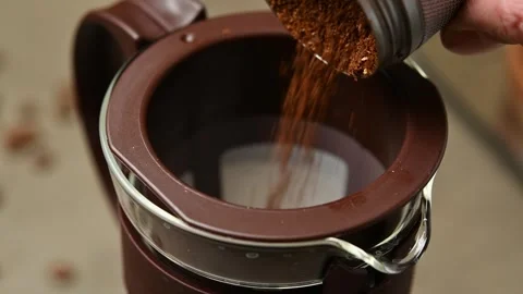 Coarse coffee grounds are poured into a cold brew filter from above during cold Stock Footage 346743727