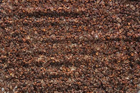 Coarse ground coffee texture with dark brown granules and shimmering highlights Photos