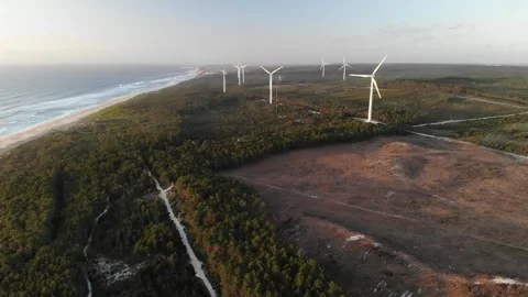 Coast beach sandy with big waves and windmills in the background in portugal Stock Footage 247501754
