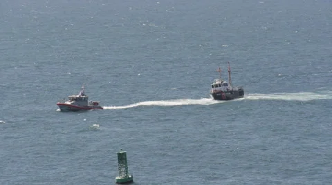 Coast guard rescue - ship under tow entering harbor Stock Footage 66427051