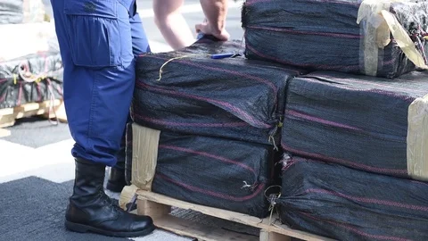 Coast Guard securing pallet of seized cocaine with shrinkwrap Stock-Footage 96100912
