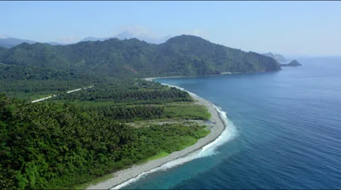 Coast line with beach, forest towards forest covered mountain range Stock Footage 25328133