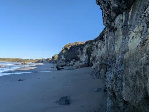 Coastal bluff erosion and dramatic rock formations along a scenic beach Stock Photos