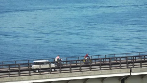 Coastal bridge with cyclists riding past the ocean, Hakodate, Japan, 2026.09.10. Stock Footage 345362876