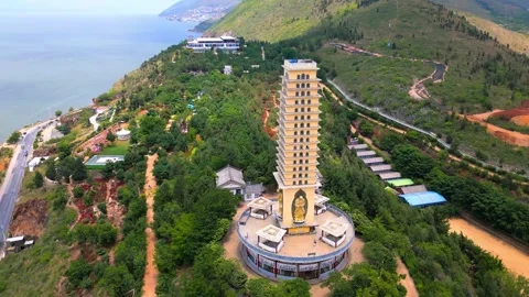 Coastal Buddhist Pagoda Complex with Multi-Story Tower and Buddha Statue Stock Footage 301088533