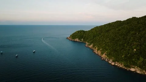 Coastal cliffs and calm sea with distant boats. Koh Tao, Thailand. Stock Footage 301943219