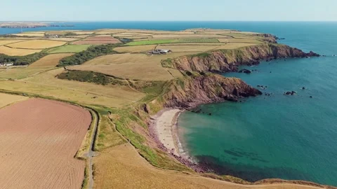 Coastal Cliffs and Sandy Cove Under Summer Sun, High Angle View 스톡 동영상 345522459