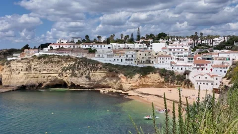 Coastal cliffs and whitewashed houses overlooking beach in Carvoeiro Portugal Stock Footage 311505458