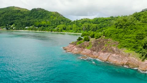 Coastal cliffs blending into turquoise waters and beaches. Praslin, Seychelles. Stock Footage 311005761