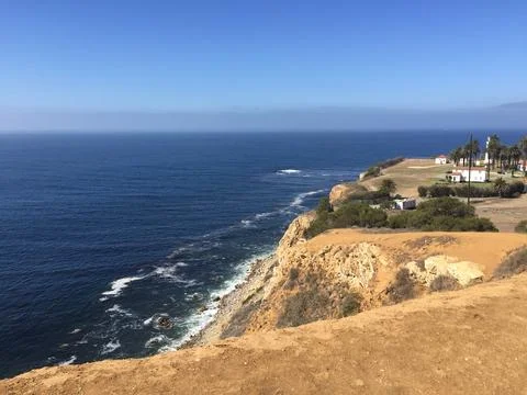 Coastal Cliffs Embrace the Tranquil Waves Under a Clear Blue Sky Foto stock