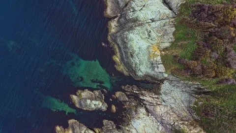 Coastal cliffs meet clear waters in stunning aerial view of shoreline Stock Footage 325724613