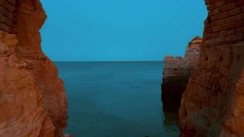 Coastal cliffs meet tranquil waters in Portugal during twilight hours Stock Footage 312326545