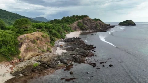 Coastal cliffs meet turquoise waves under cloudy skies Vídeo Stock 333398905