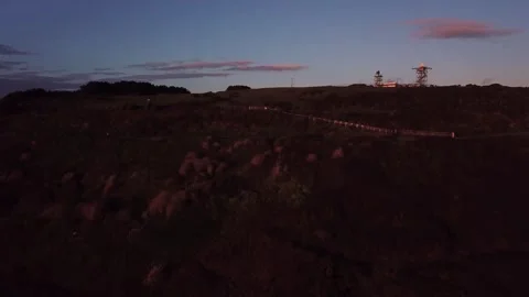 Coastal Cliffs to Radar Tower — Ascending Aerial Reveal at Sunset Stock Footage 325855241