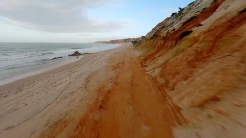 Coastal cliffside view with ocean waves crashing onto beach 스톡 동영상 346091159