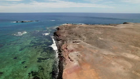 Coastal drone shot of volcanic cliffs and vivid blue water in Fuerteventura Stock Footage 309829668