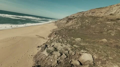 Coastal dunes meet sandy beach with gentle waves Video stock 341824096