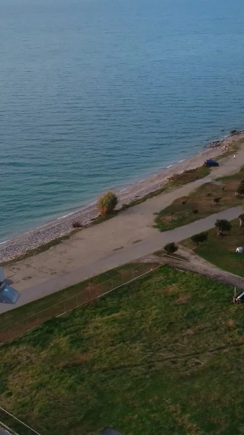 Coastal Fields and Pebble Beach with Clear Water and Dirt Path Stock Footage 343993211