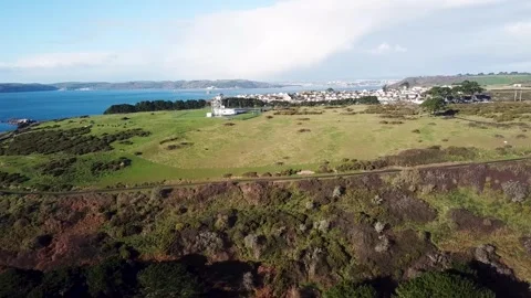 Coastal Fields and Radar Site — Lateral Aerial Arc with City Backdrop Stock Footage 325854508