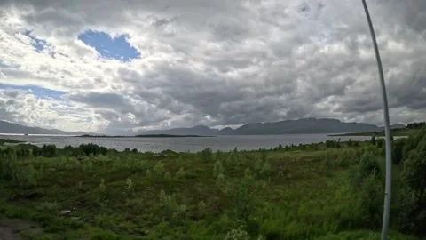 Coastal fields, bus stop, and fjord mountain panorama in Andoya Norway Stock-Footage 343380187
