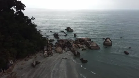 Coastal flight over sandy beach pan upwards towards the cloudy sky Video stock 246176467