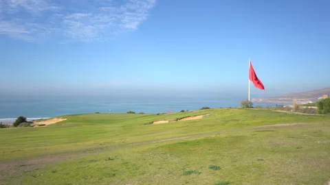 Coastal Golf Course with Moroccan Flag Overlooking the Ocean Vídeos de archivo 334939251