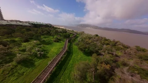 Coastal landscape features lush greenery, beach, and waterfront structures Stock Footage 345060504