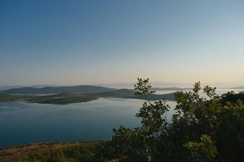 Coastal landscape with pine trees overlooking calm water and distant islands Stock-Fotos
