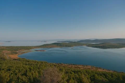 Coastal landscape with pine trees overlooking calm water and distant islands Stock-Fotos