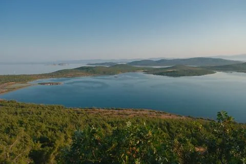 Coastal landscape with pine trees overlooking calm water and distant islands Stock-Fotos