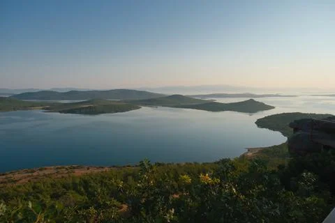 Coastal landscape with pine trees overlooking calm water and distant islands Stock-Fotos