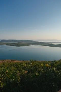 Coastal landscape with pine trees overlooking calm water and distant islands Stock-Fotos