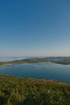 Coastal landscape with pine trees overlooking calm water and distant islands Stock-Fotos