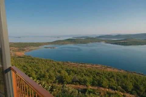 Coastal landscape with pine trees overlooking calm water and distant islands Stock-Fotos