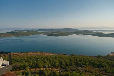 Coastal landscape with pine trees overlooking calm water and distant islands Stock Photos
