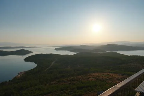 Coastal landscape with pine trees overlooking calm water and distant islands Stock-Fotos
