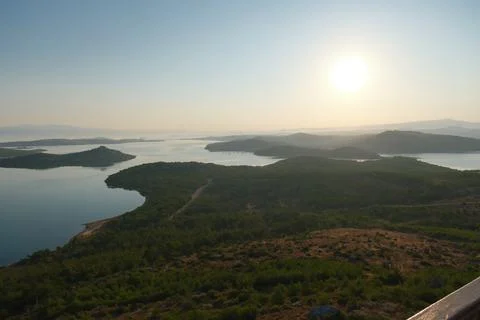 Coastal landscape with pine trees overlooking calm water and distant islands Stock-Fotos