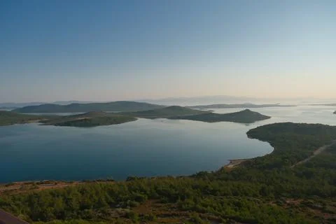 Coastal landscape with pine trees overlooking calm water and distant islands Stock-Fotos