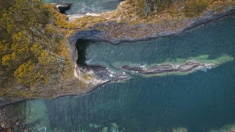 Coastal landscape with sharp cliffs and turquoise water seen from the air Stock Photos