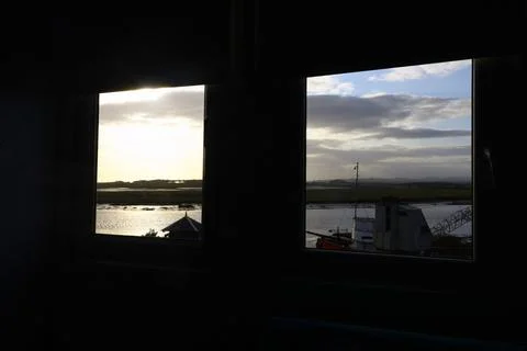 Coastal landscape viewed through windows with water, wetlands and distant hil 写真素材