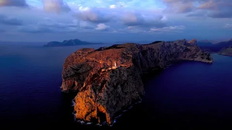 Coastal lighthouse on rugged cliffs at sunrise overlooking mediterranean sea Stock Footage 343695840