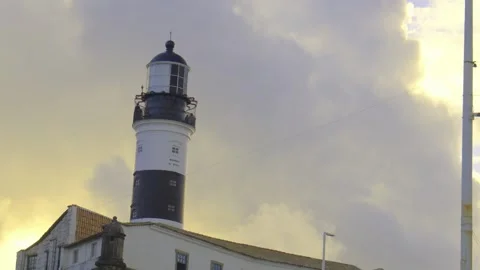 Coastal lighthouse at sunset against a dramatic sky Stockbeeldmateriaal 319207026