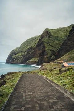 Coastal mountain landscape with paved path leading to ocean, serene and dra.. Stock Photos